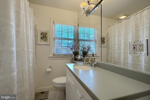 bathroom with tile patterned flooring, baseboards, vanity, and toilet