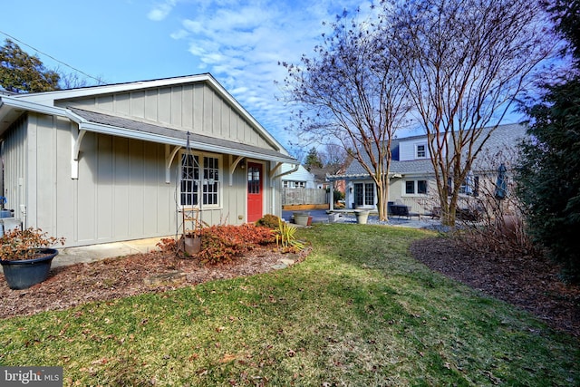 view of front of property with board and batten siding and a front lawn