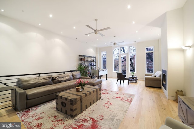 living room featuring baseboards, light wood-style flooring, and recessed lighting