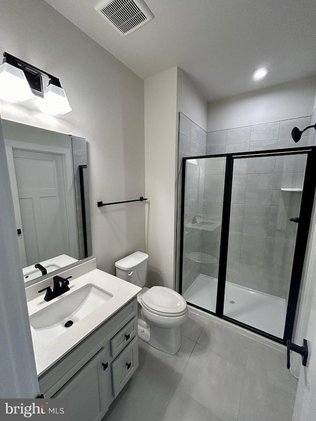 bathroom featuring vanity, toilet, and a shower with door