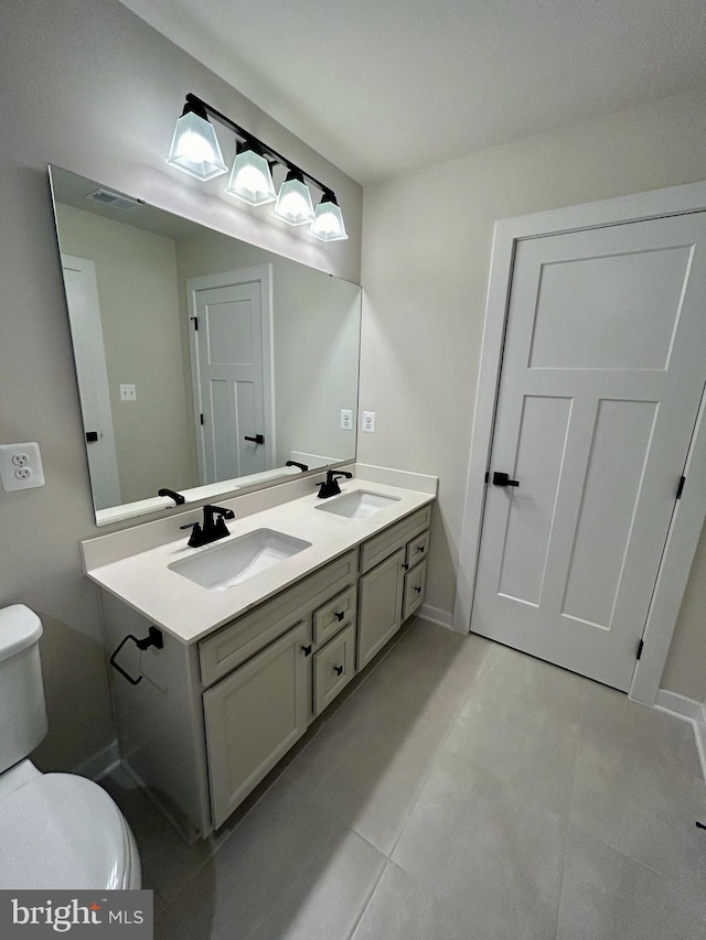 bathroom featuring vanity, tile patterned flooring, and toilet