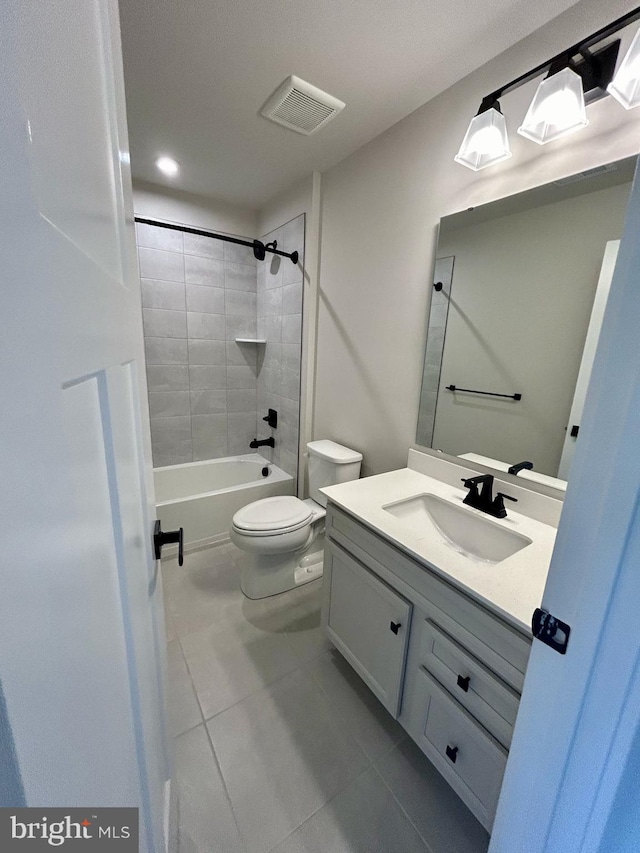 full bathroom featuring vanity, tile patterned flooring, toilet, and tiled shower / bath