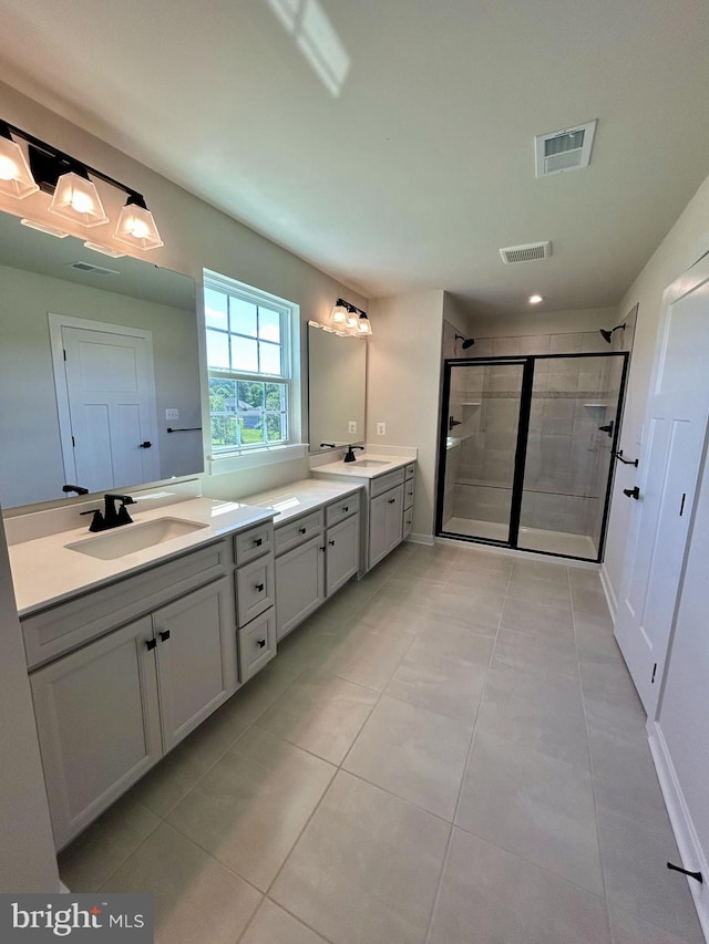 bathroom featuring walk in shower, vanity, and tile patterned flooring