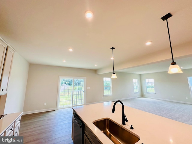 kitchen with sink, white cabinetry, light hardwood / wood-style flooring, dishwasher, and pendant lighting