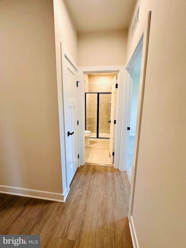 hallway with light hardwood / wood-style floors