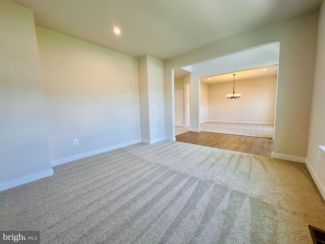 carpeted empty room with a chandelier