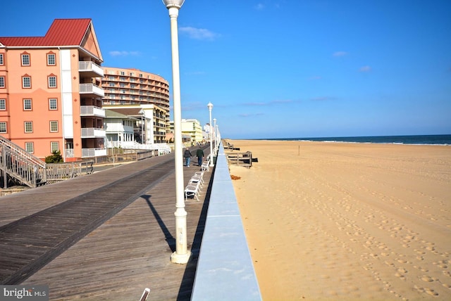 view of home's community with a water view and a beach view