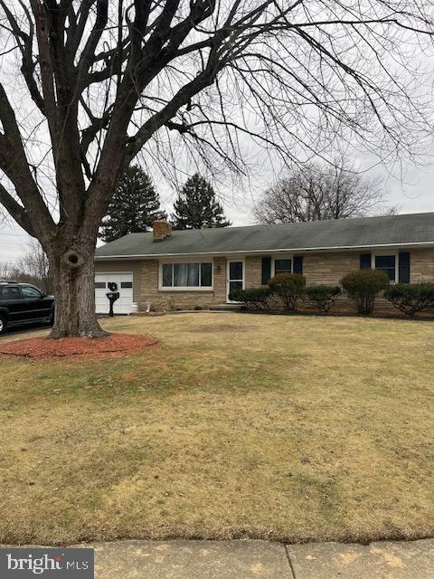 view of front of house with a garage and a front lawn