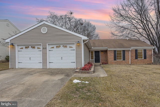 single story home featuring a garage and a yard