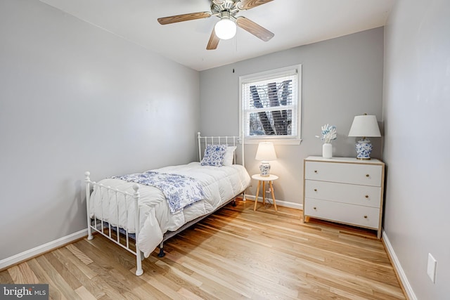 bedroom featuring light wood-style flooring, baseboards, and a ceiling fan