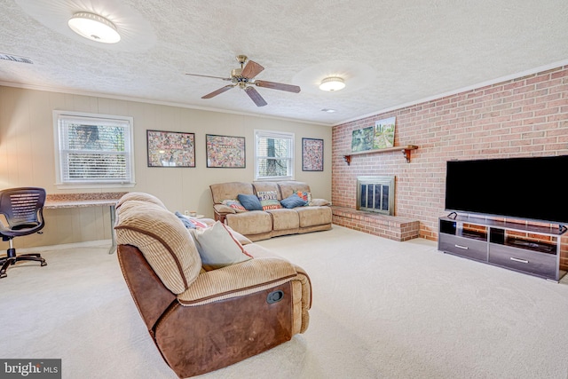 carpeted living room featuring a textured ceiling, ornamental molding, a brick fireplace, and visible vents