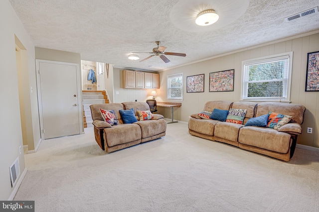 living area with light carpet, stairway, visible vents, and a wealth of natural light