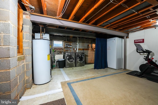 basement featuring washing machine and dryer, water heater, and a sink