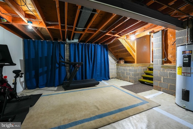 unfinished basement with stairway and electric water heater