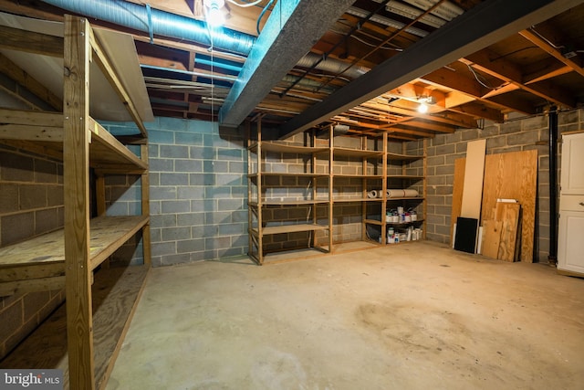 unfinished basement featuring concrete block wall