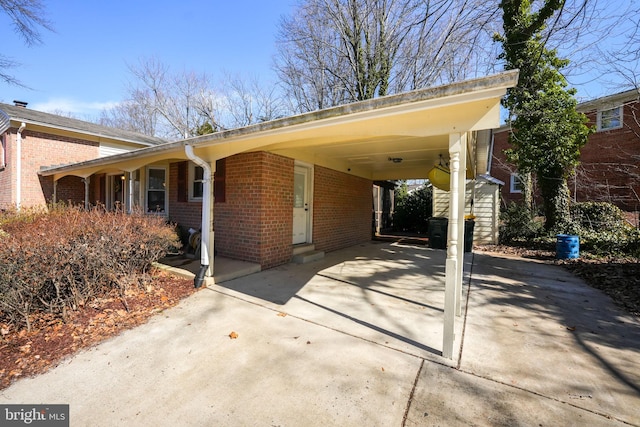 exterior space featuring a carport, brick siding, and driveway