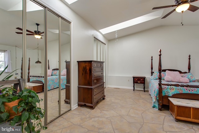 bedroom featuring multiple closets, lofted ceiling with skylight, and ceiling fan