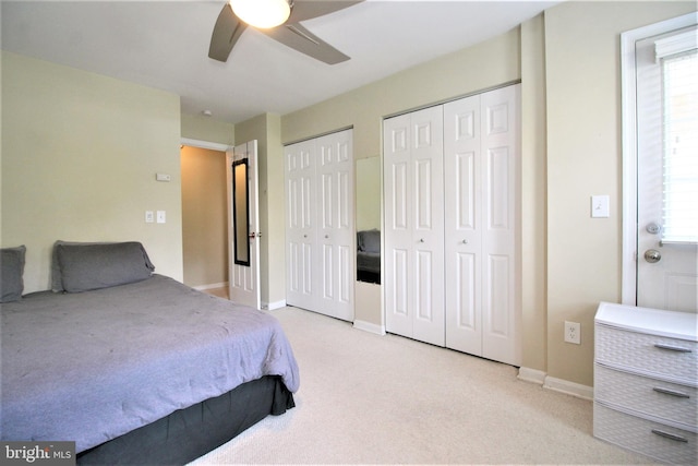 bedroom featuring ceiling fan, baseboards, multiple closets, and carpet flooring