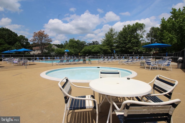 community pool featuring a patio area and fence