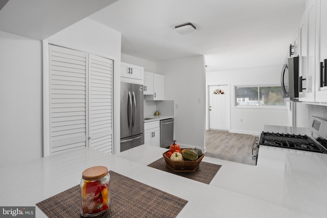 kitchen featuring appliances with stainless steel finishes, decorative backsplash, and light countertops