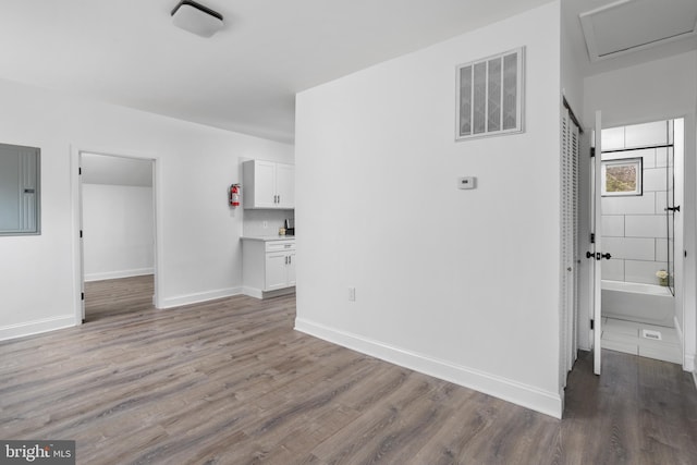 interior space with visible vents, light wood finished floors, electric panel, and baseboards