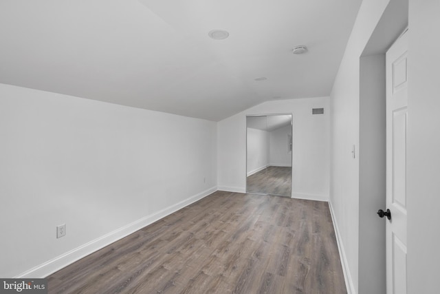 additional living space with lofted ceiling, baseboards, visible vents, and wood finished floors