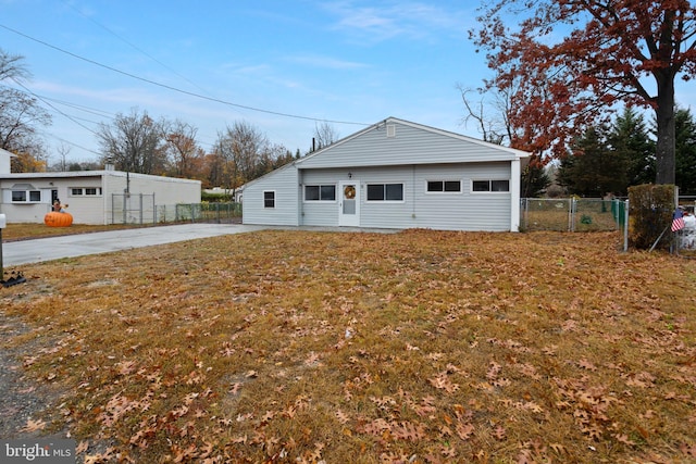 rear view of property featuring fence and a yard