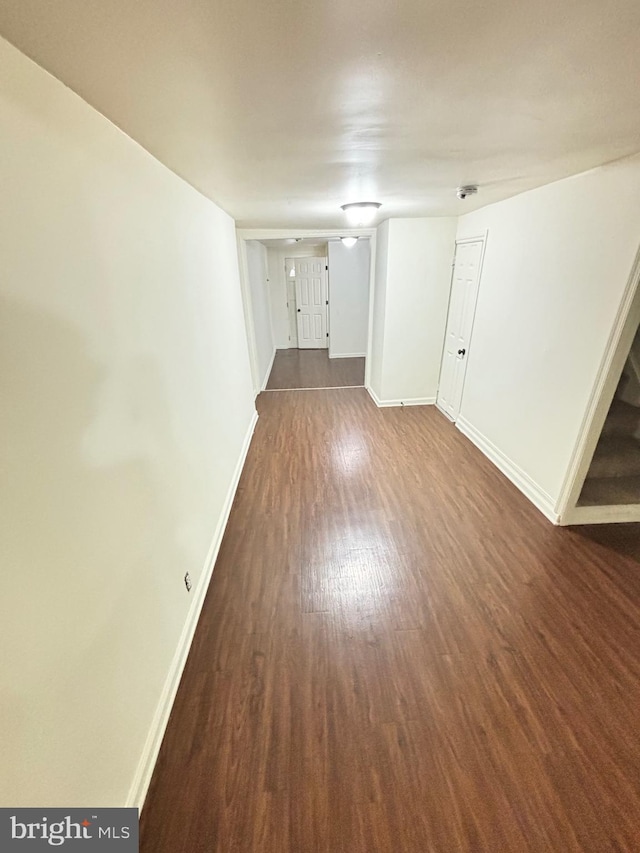 unfurnished room with dark wood finished floors and baseboards