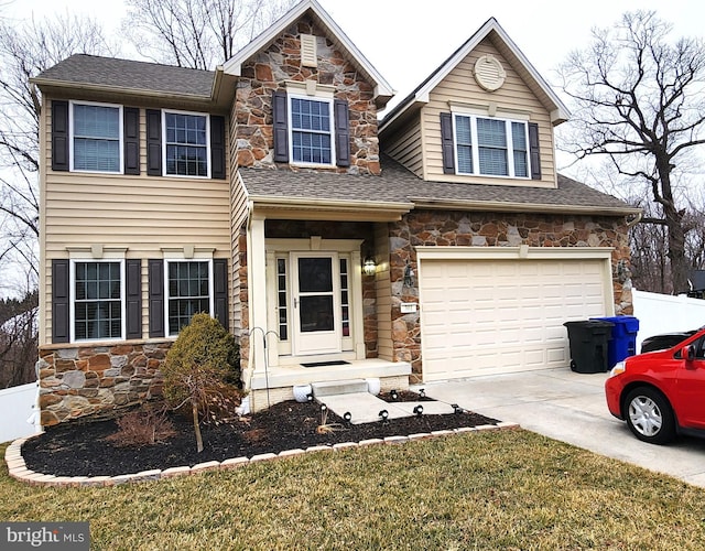 view of front facade with driveway, a shingled roof, stone siding, an attached garage, and fence