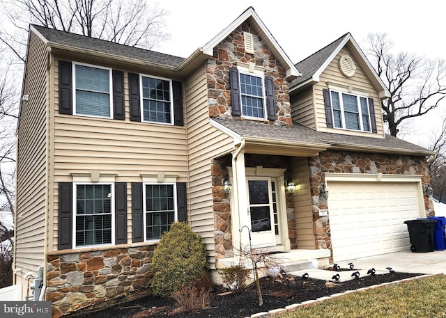 view of front of house with a shingled roof, stone siding, an attached garage, and concrete driveway