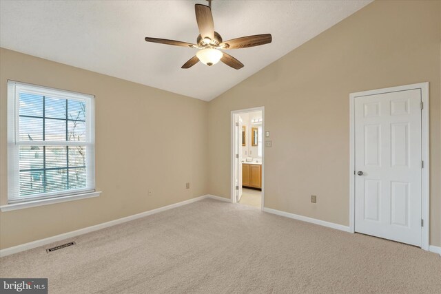 unfurnished bedroom with lofted ceiling, baseboards, visible vents, and light colored carpet