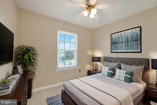 carpeted bedroom with a ceiling fan, baseboards, and a textured ceiling