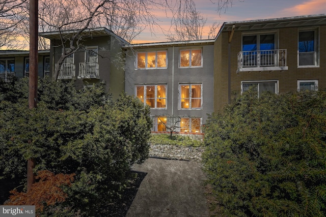 back of house at dusk with brick siding