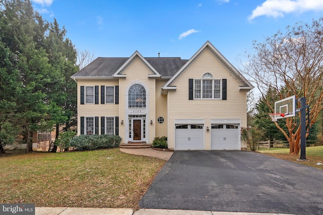 view of front of home featuring driveway, a garage, and a front lawn