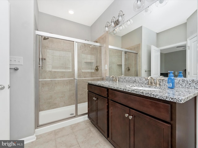 bathroom with tile patterned flooring, vanity, and walk in shower