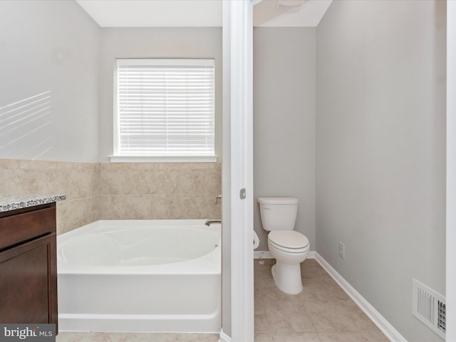 bathroom featuring a tub to relax in, toilet, vanity, and tile patterned flooring