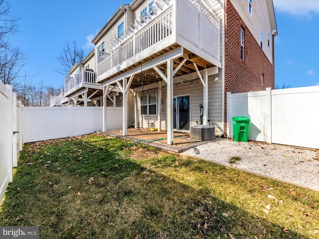 rear view of house featuring central air condition unit, a patio, and a lawn