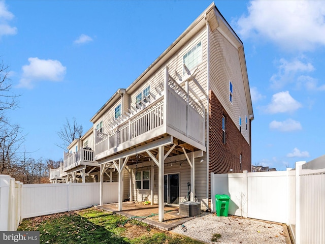 back of property with central AC, a deck, and a patio area