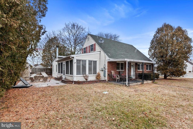 back of house with a yard, a sunroom, and a patio area