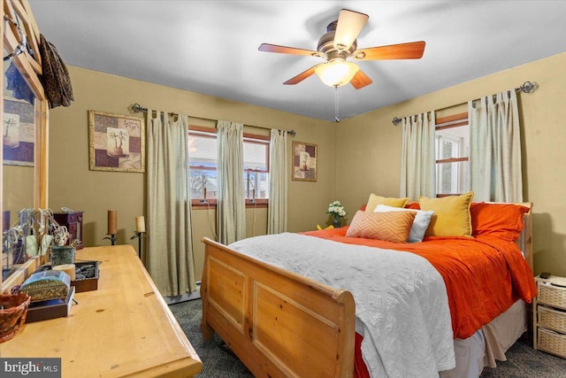 bedroom with ceiling fan and dark colored carpet