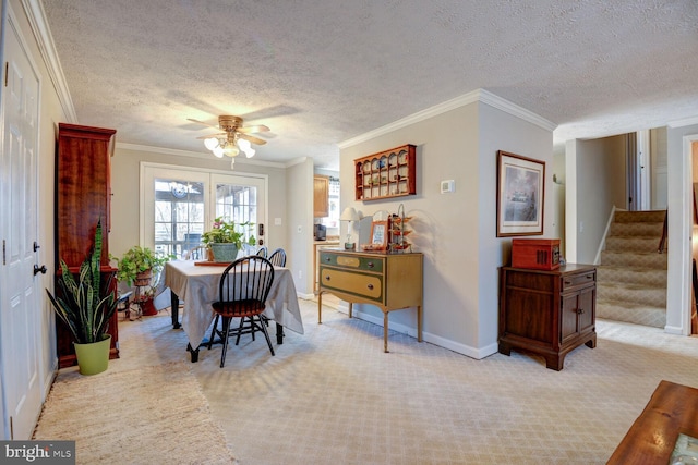 dining space featuring ceiling fan, light colored carpet, baseboards, ornamental molding, and stairway