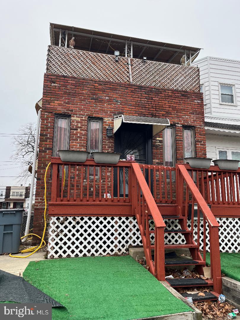 rear view of property featuring a wooden deck