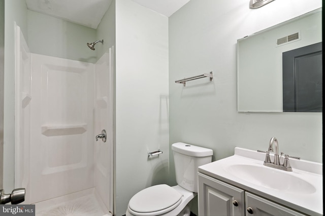 bathroom featuring vanity, toilet, and walk in shower