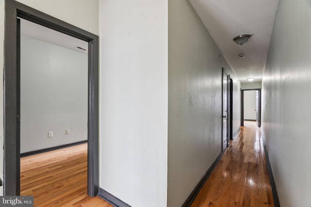 corridor with hardwood / wood-style floors