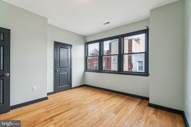 empty room with light hardwood / wood-style flooring