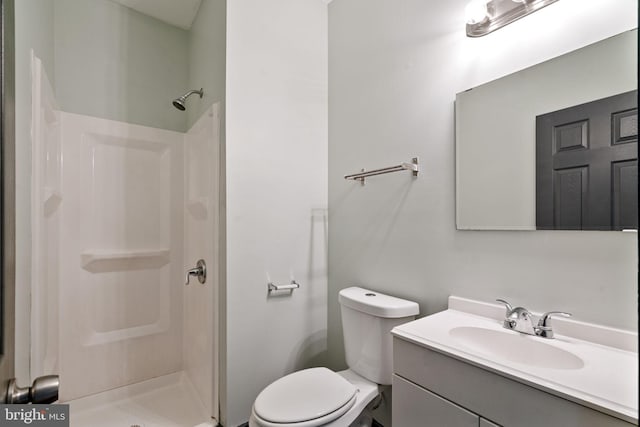 bathroom featuring vanity, toilet, and walk in shower