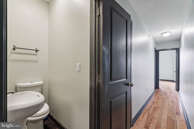 bathroom with toilet and hardwood / wood-style floors