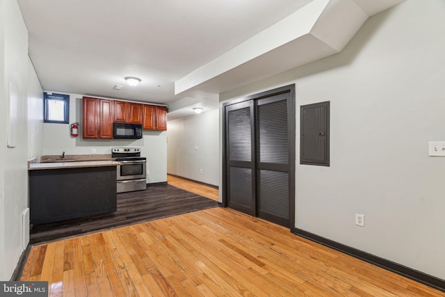 kitchen featuring dark wood-type flooring, electric panel, and stainless steel electric range oven