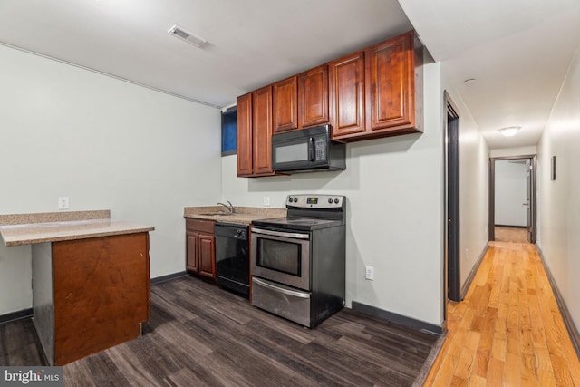 kitchen featuring sink, dark wood-type flooring, and black appliances