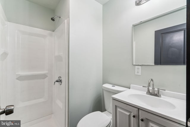 bathroom featuring vanity, walk in shower, and toilet